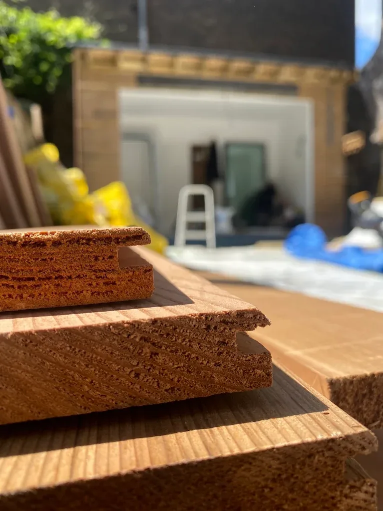 Cedar cladding boards on site, specified and priced in the quote.